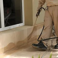 General pest control technician spraying exterior perimeter around a home in Fort Collins, CO